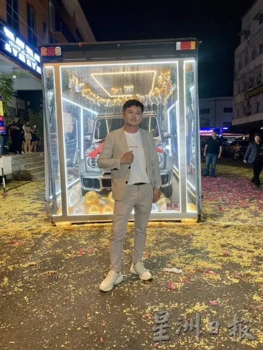 Huang standing infront of his new car