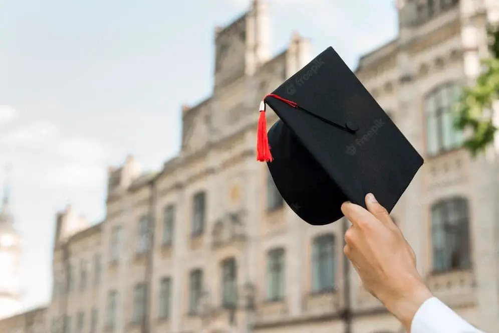 Hand holding a mortarboard 