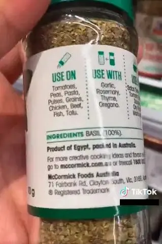 Woman holding a bottle of McCormick herbs