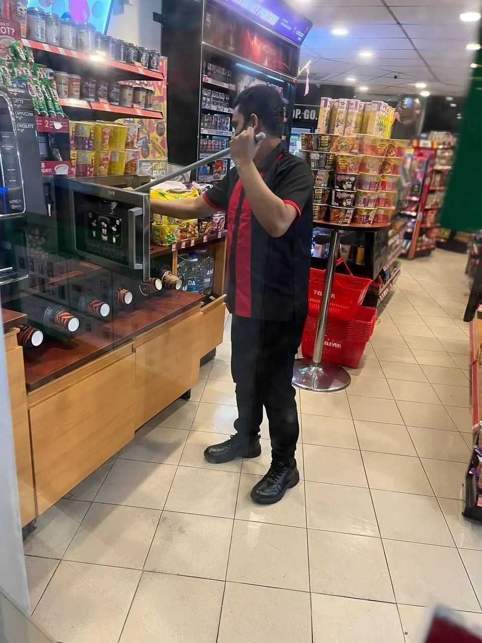 7-Eleven staff cleans microwave with mop