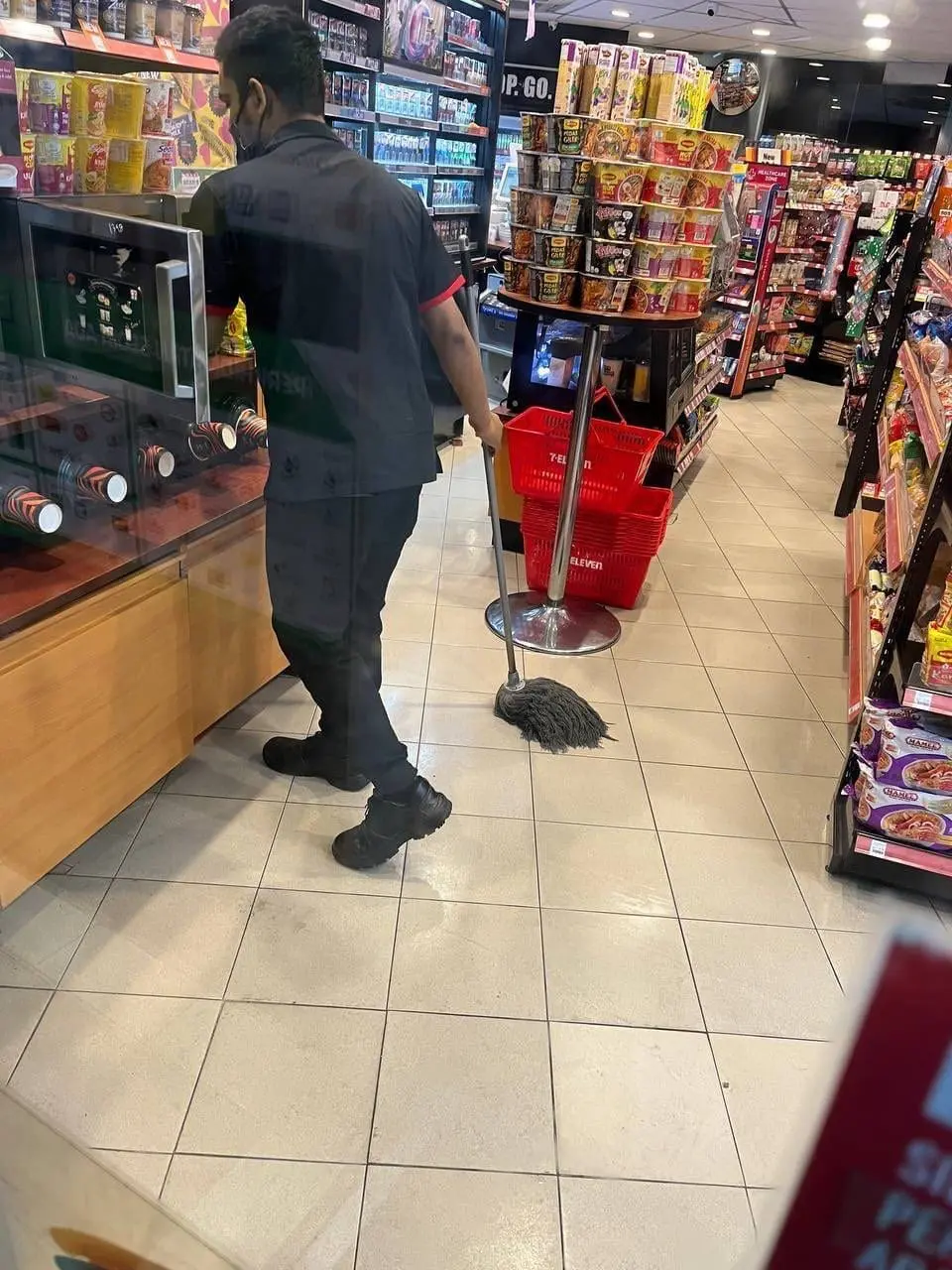 7-Eleven staff cleans microwave with mop