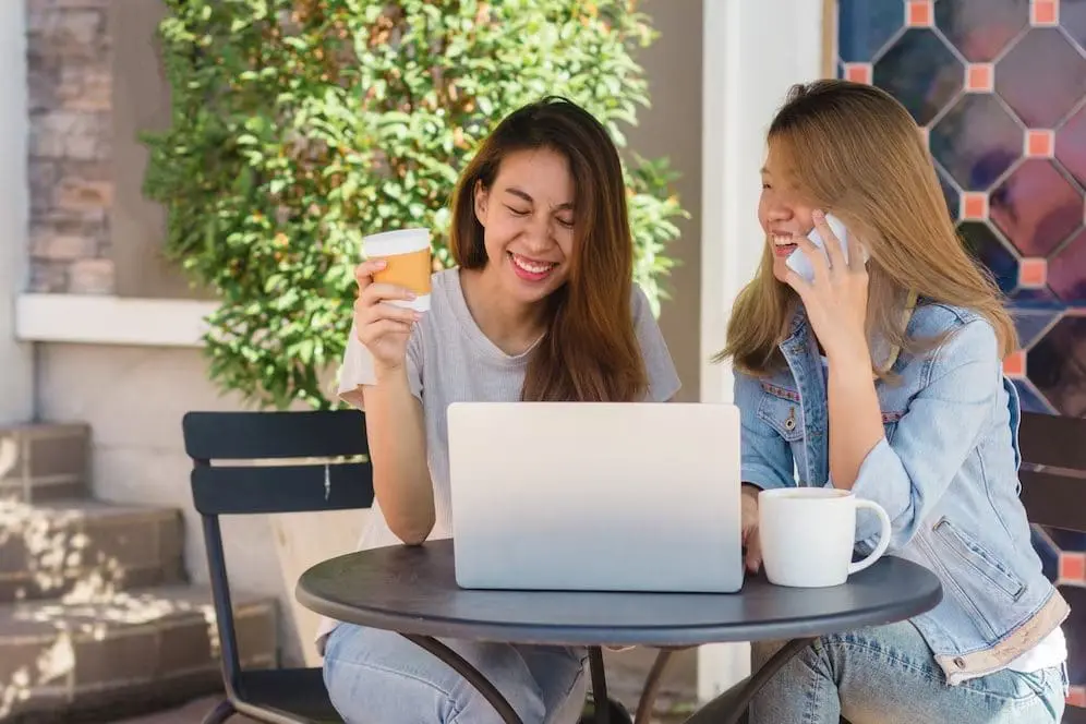 2 young women chatting with each other over coffee