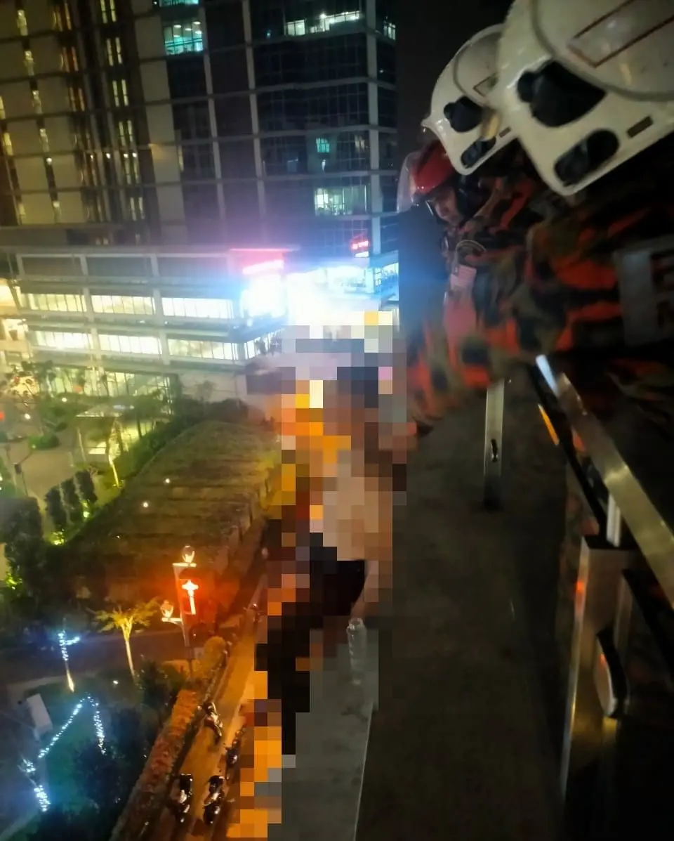 Bomba coaxing a man who attempted suicide at V Residensi Suites in Cheras