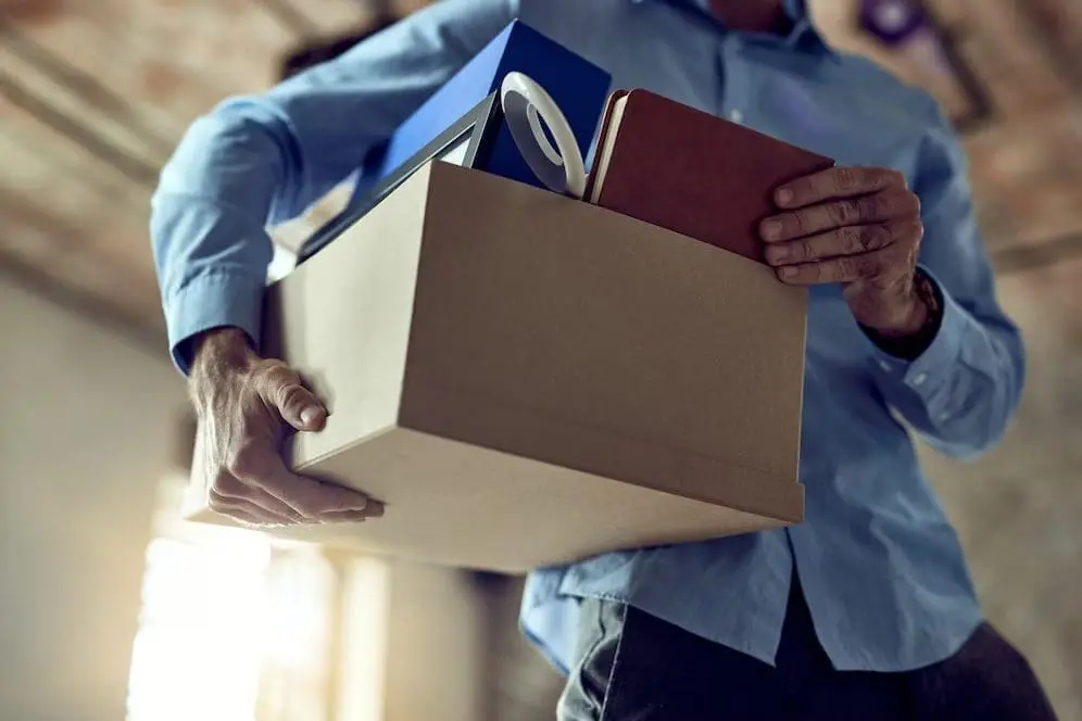 Man holding a box contained files and books