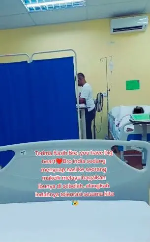 Msian man feeding food to another patient in a hospital