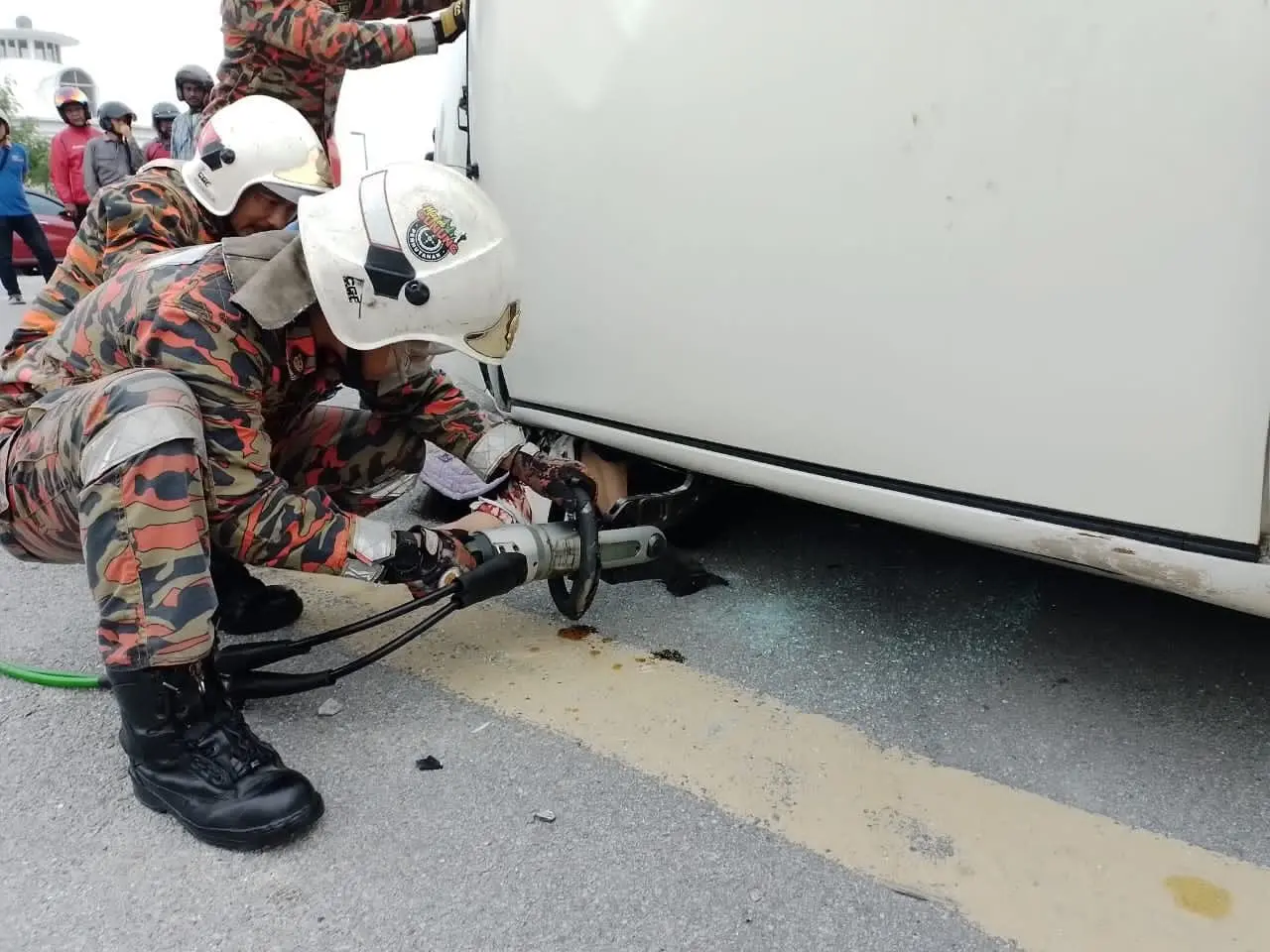 Firefighters using hydraulic cutters to extricate Ng Yoke Lin's body