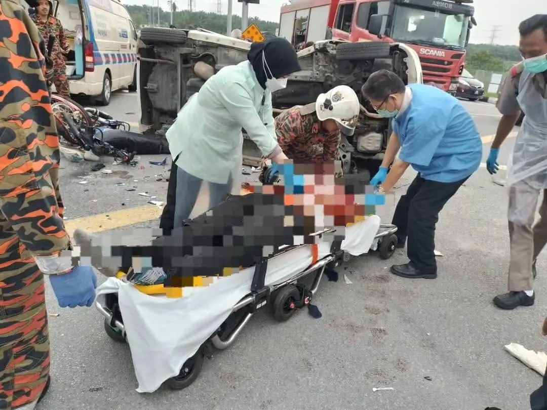 Medical personnel and firefighters attending to Ng Yoke Lin's body