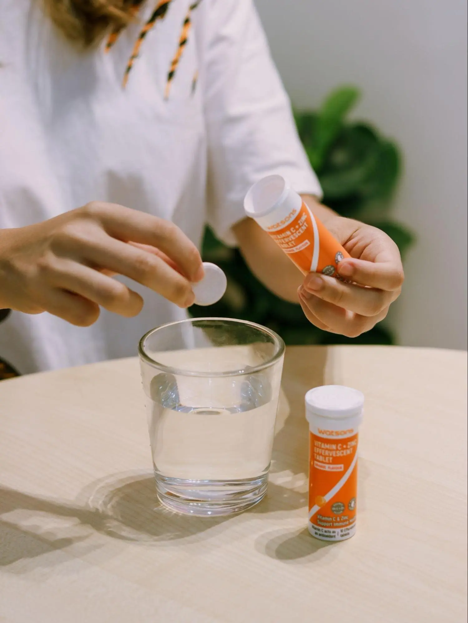 Asian woman consuming vitamins from Watsons
