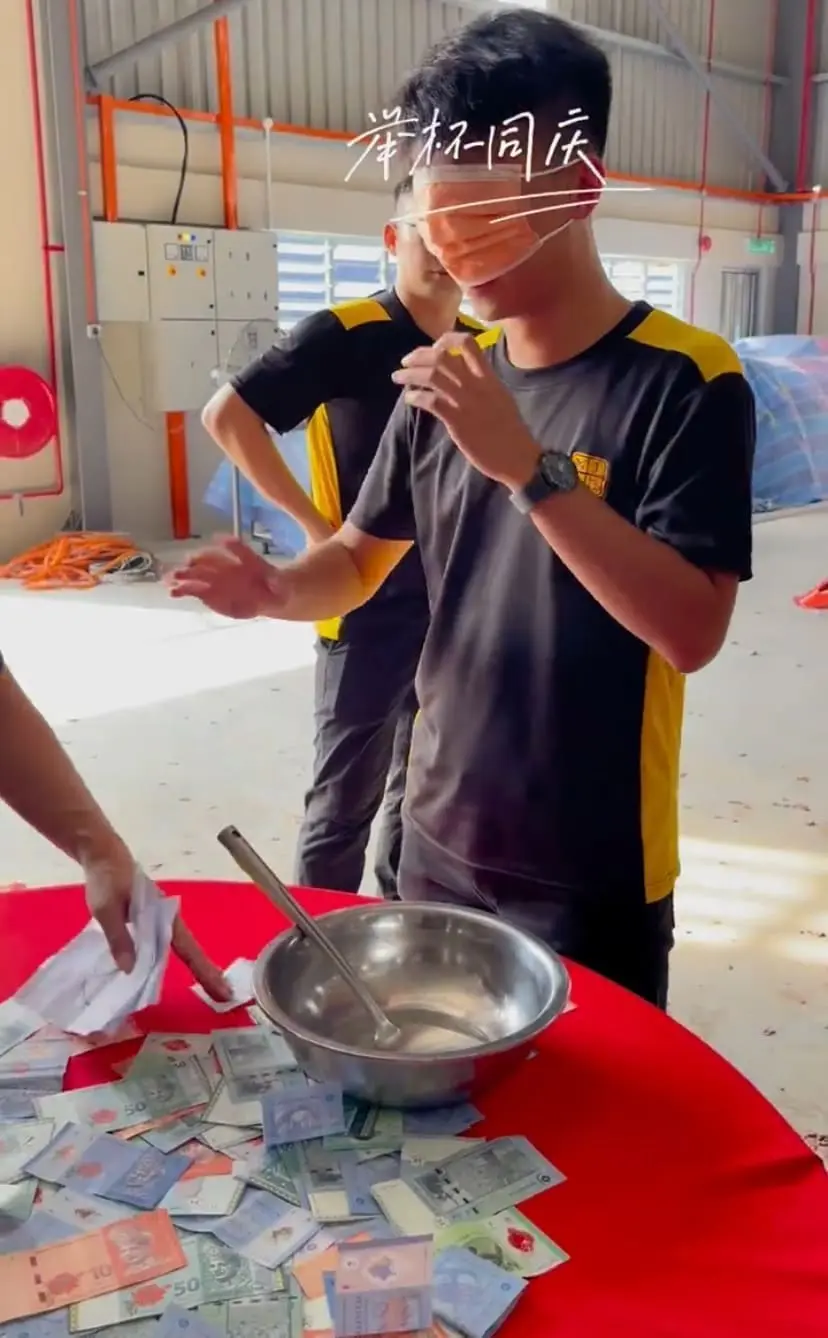 Malaysian stuff blindfolded, ready to scoop some cash on the table for CNY