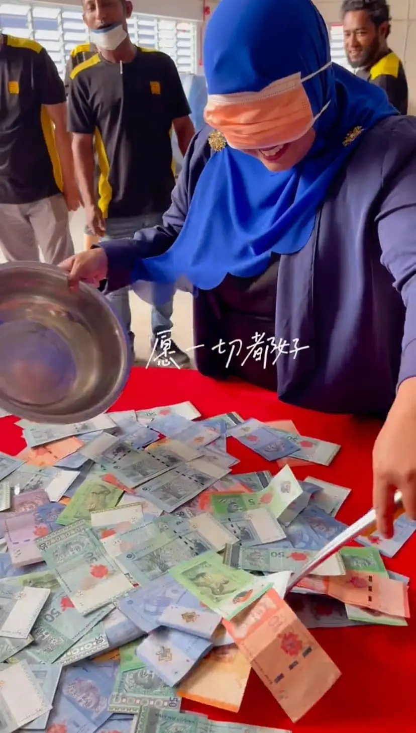Malaysian stuff blindfolded, ready to scoop some cash on the table for CNY