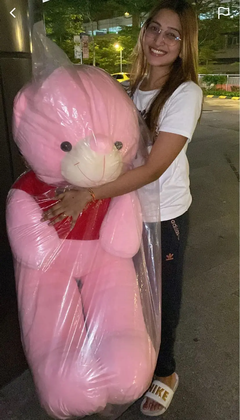 woman holding a pink teddy bear