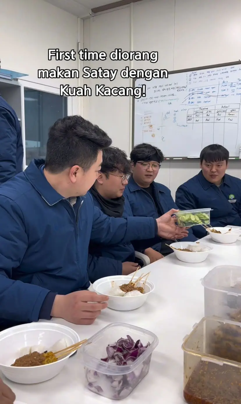 korean men enjoying satay