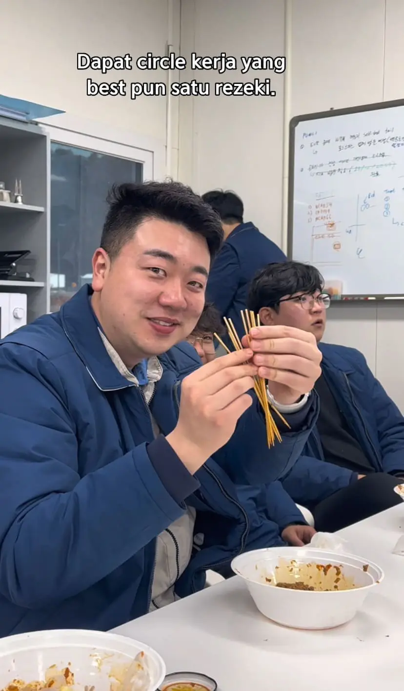 korean man holding satay stick