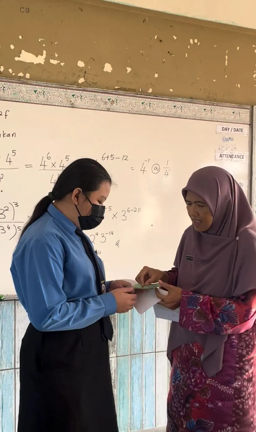 Cikgu Nor Sahidah rewards her student