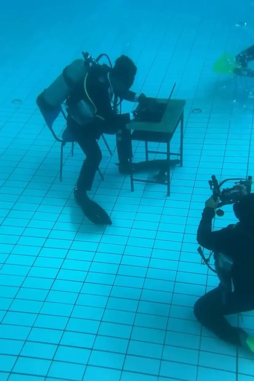 Ahmad Fudhail Ahmad Kenedi writing essay while underwater