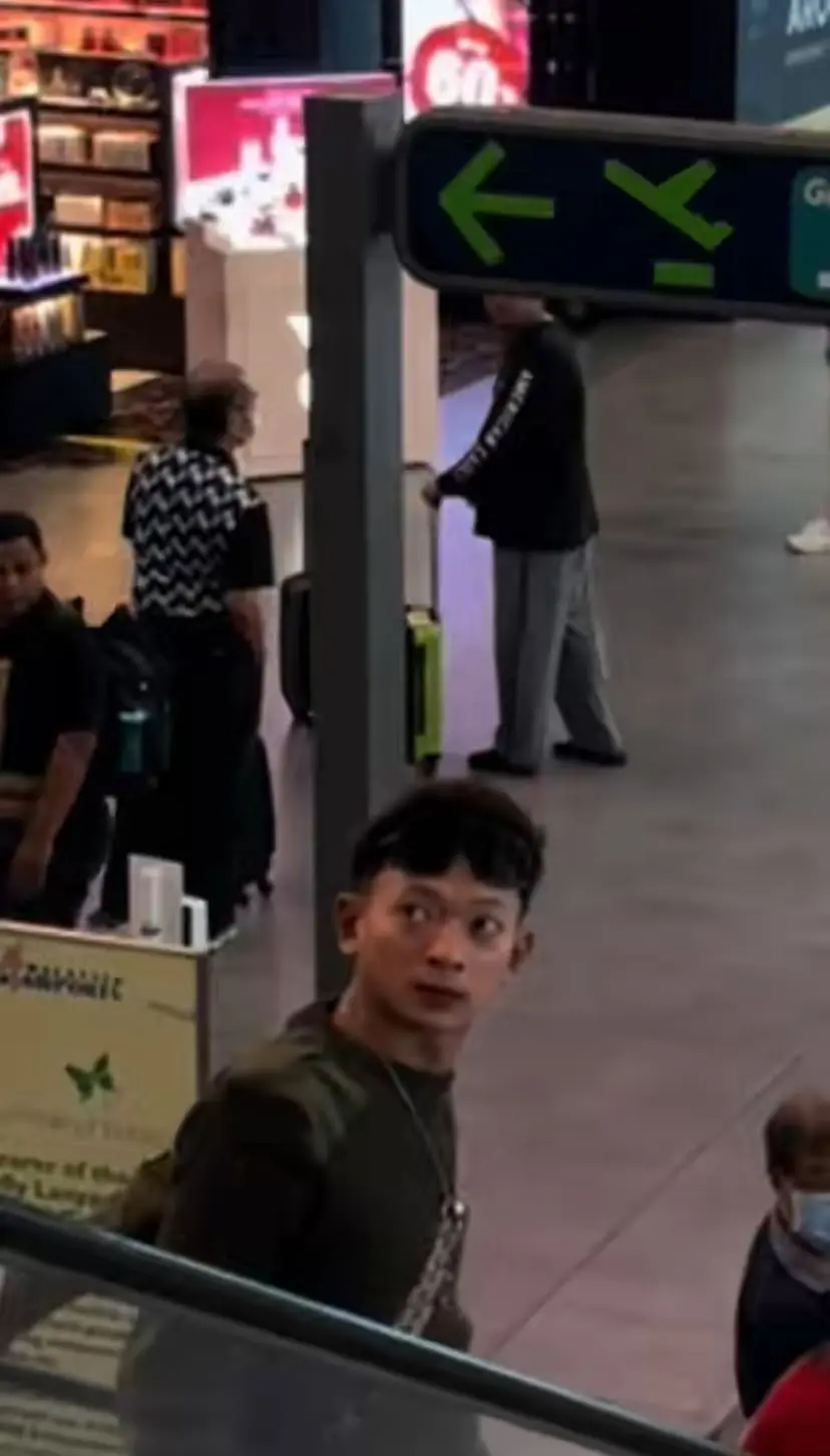 Visibly annoyed man standing on escalator with luggage by his side in KLIA2 and collided with another luggage 