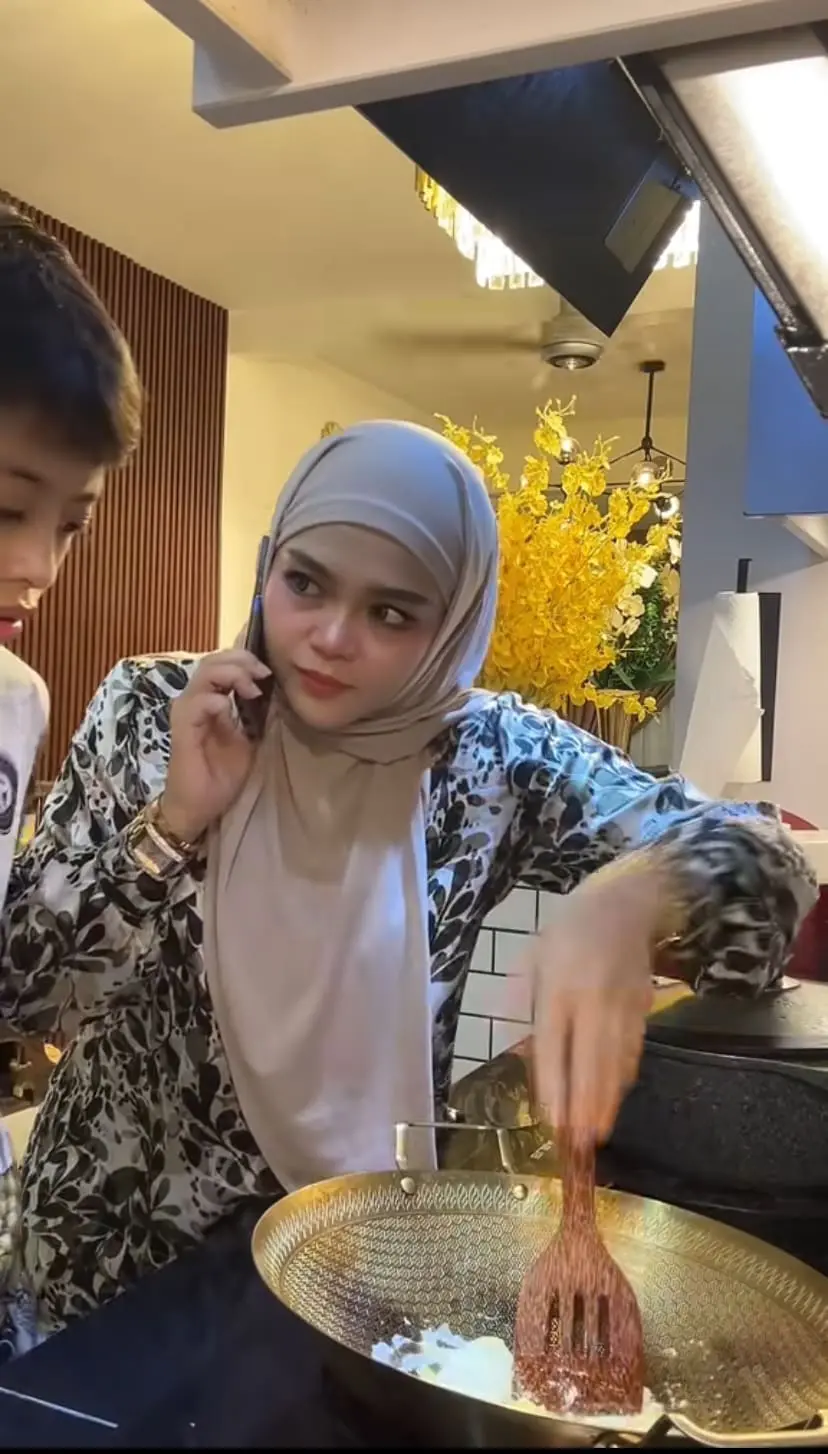 Mum attentively watching her son while looking annoyed to scramble the fried egg