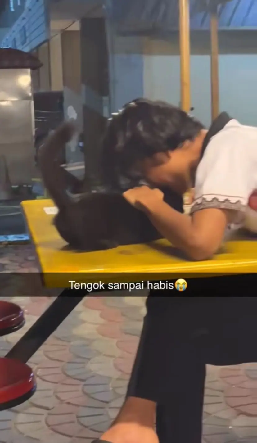 M'sian man nibbles black cat 