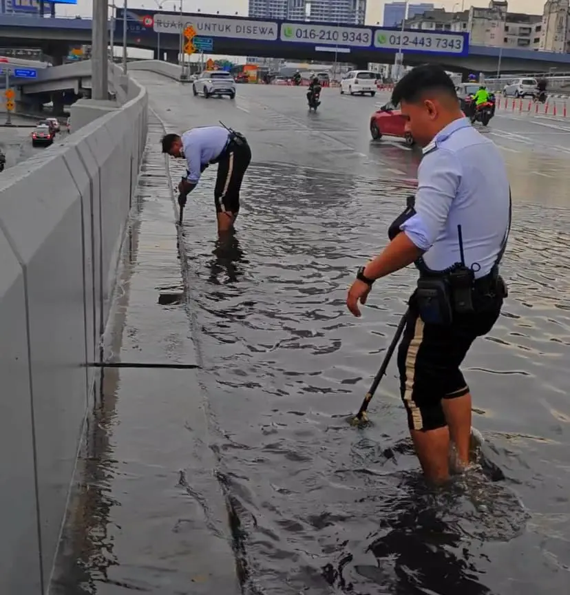 M'sian Traffic Police Officers Go Beyond Their Duty By Clearing Clogged Drains While Barefoot