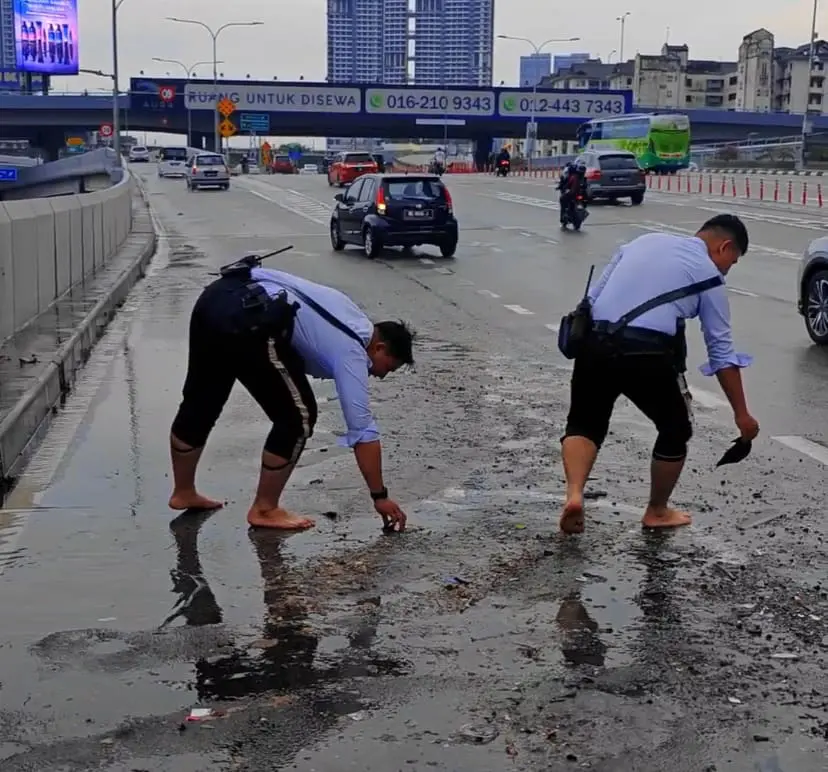 M'sian Traffic Police Officers Go Beyond Their Duty By Clearing Clogged Drains While Barefoot
