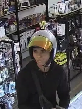 Man in helmet who runs off with 2 iPhones after pretending to do comparison