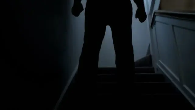 person holding fist in dark background