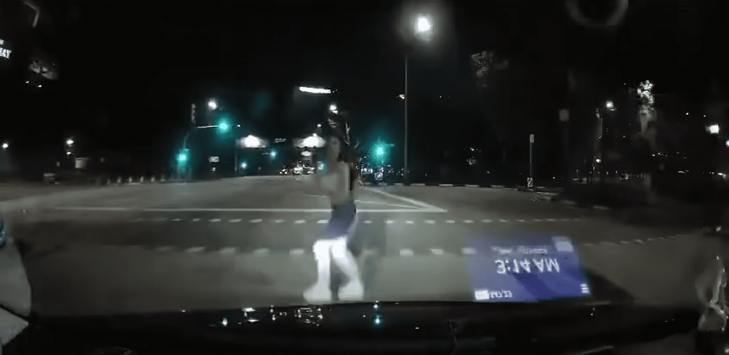 Jaywalking woman looks up from her phone