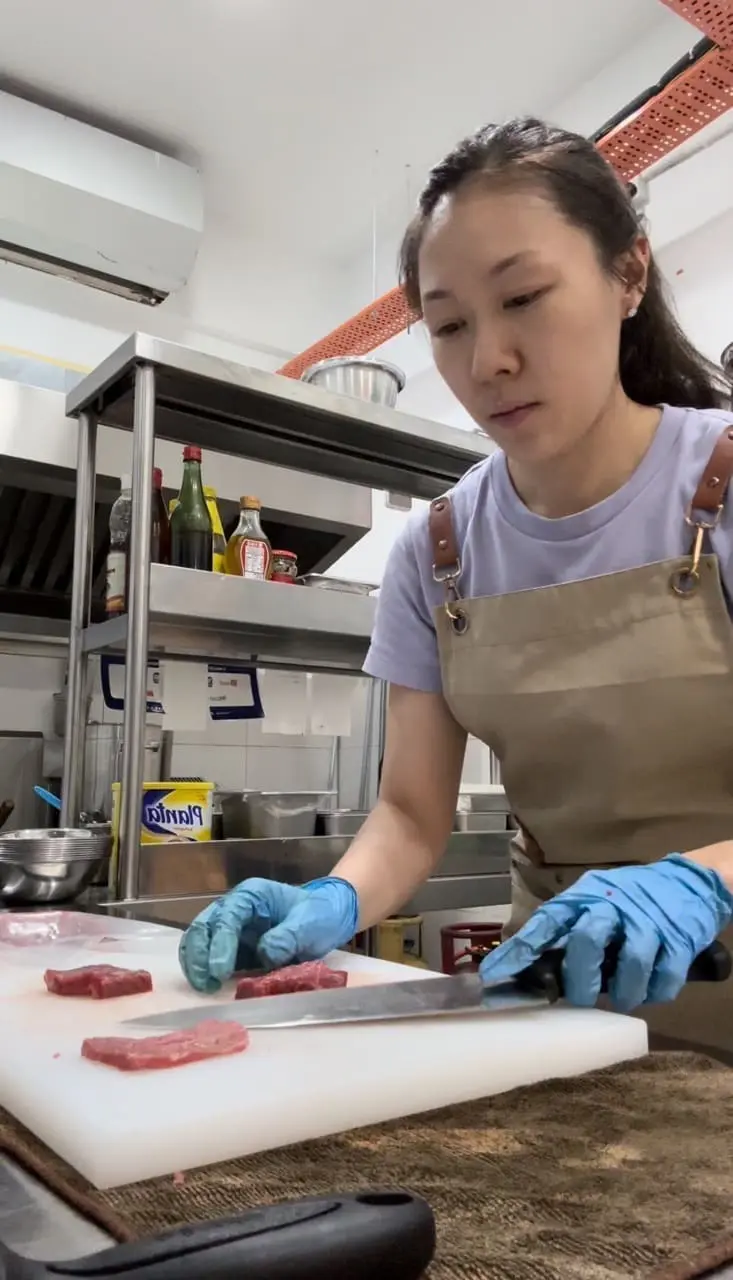 Jia Li cutting ingredients for her restaurant