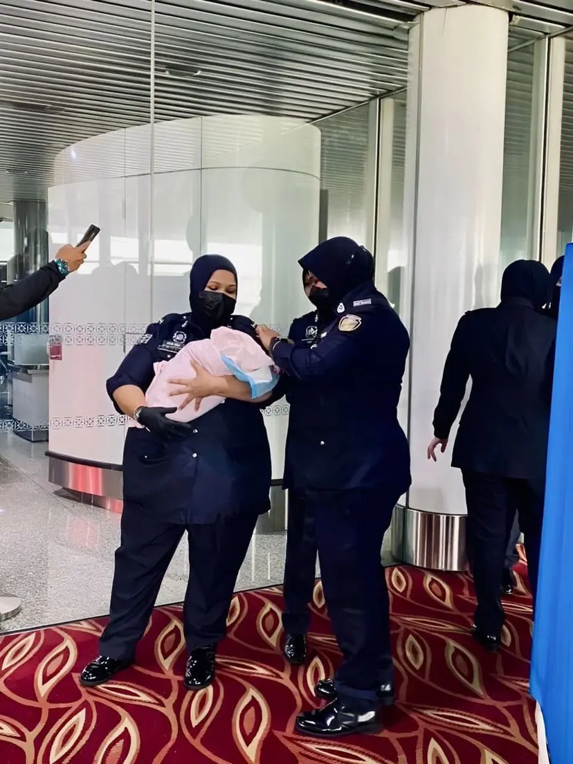Officers attending to newborn baby at KLIA Terminal 1 waiting area
