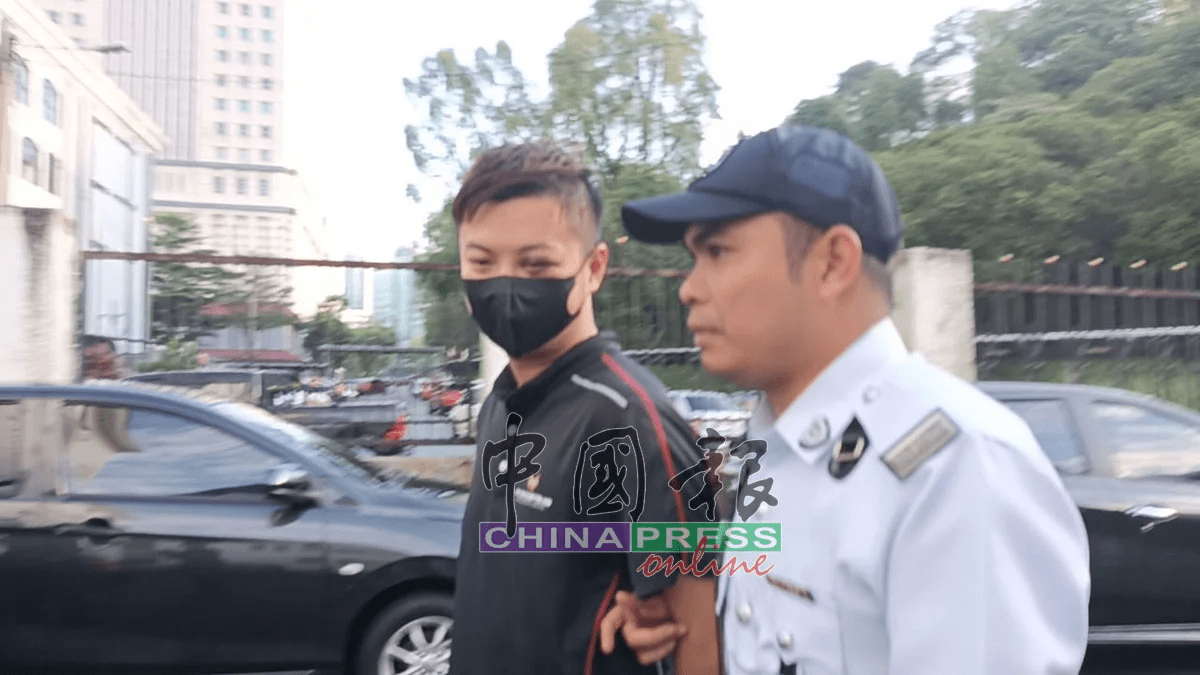 Kok Zi Kang being escorted by police