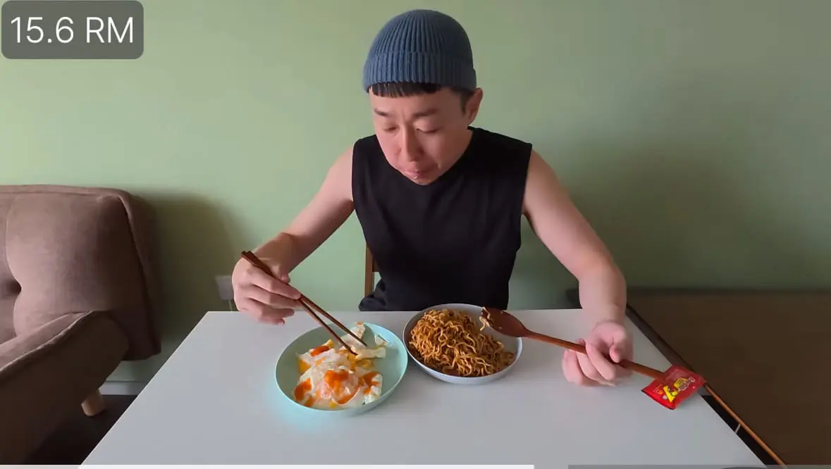korean man eats instant noodles and eggs in malaysia