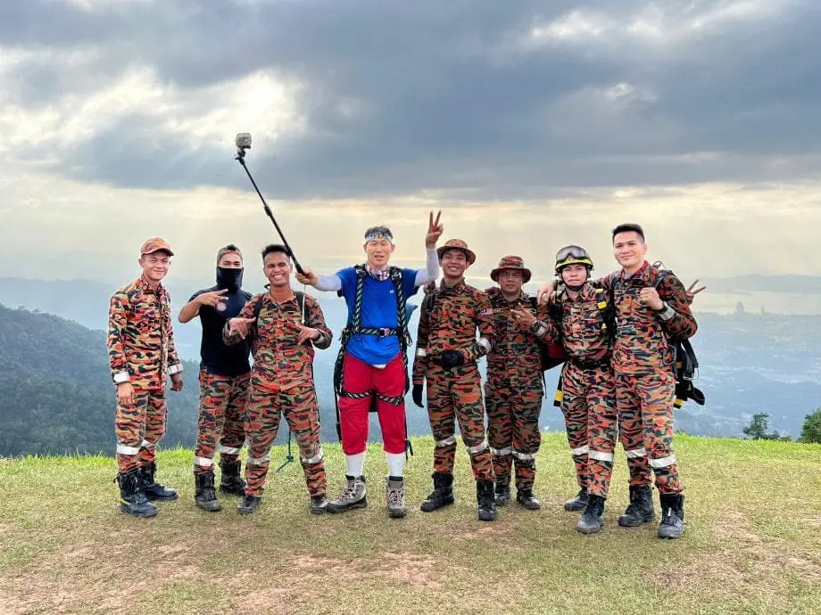Korean man Cha Woo-sung poses with firefighters for a photo 