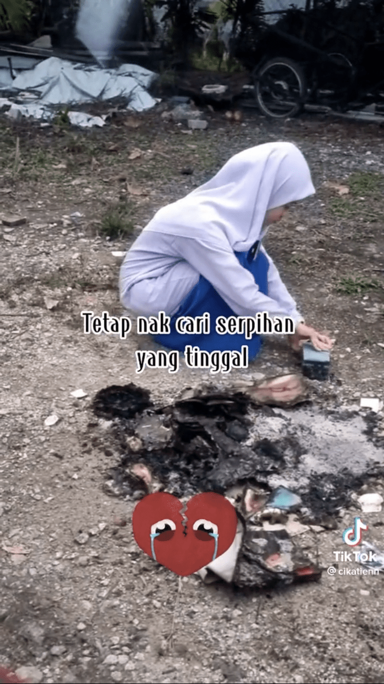 Girl searches through burnt K-Pop collectibles