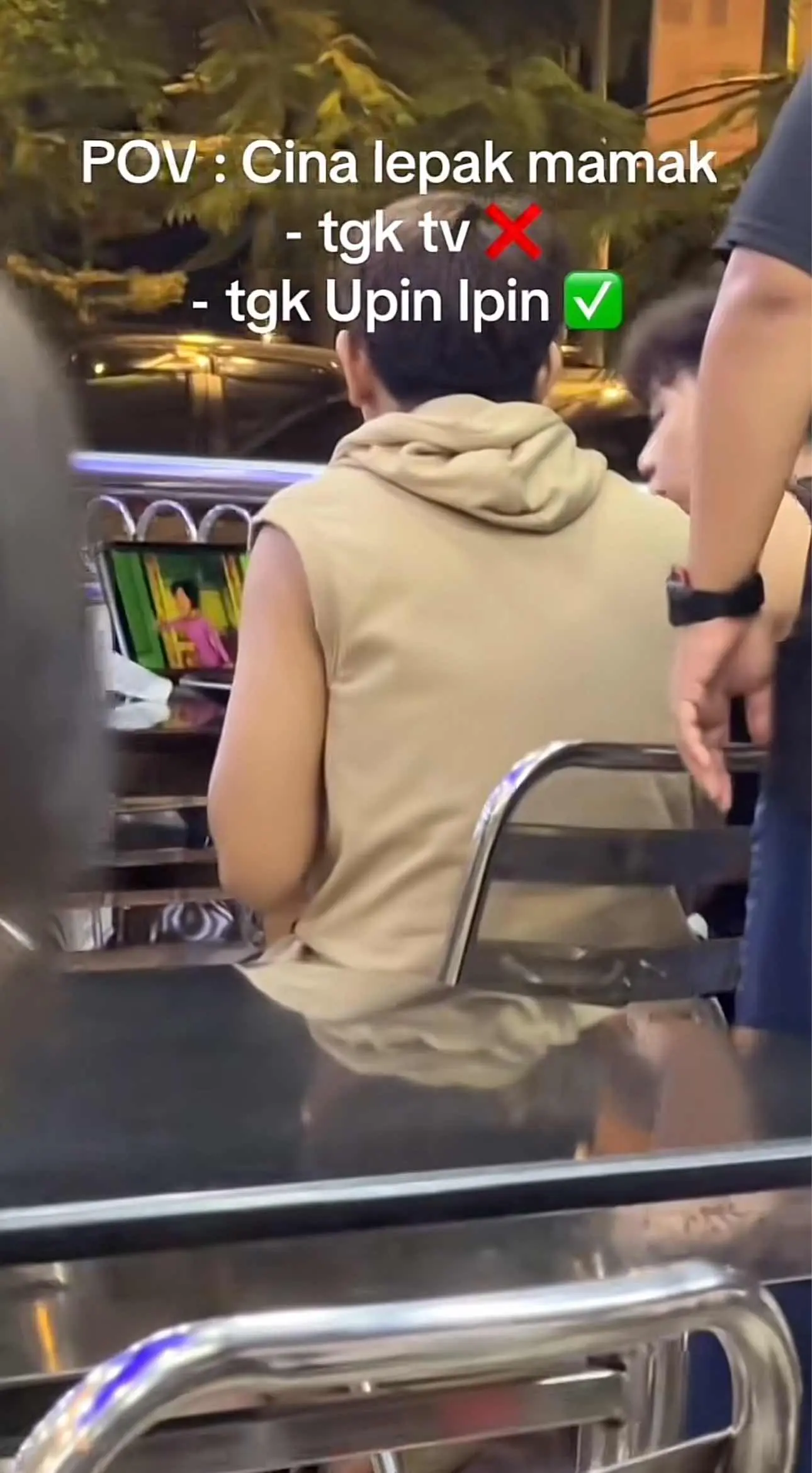 Two Chinese boys watching Upin Ipin at mamak