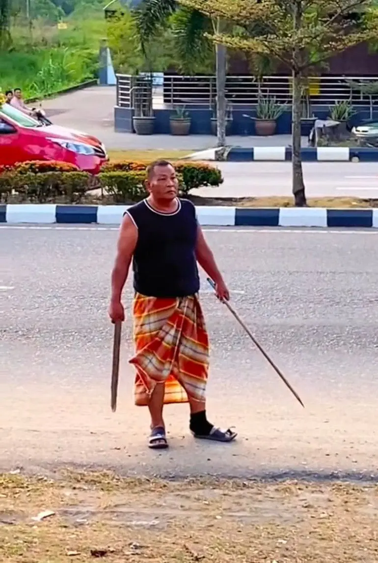 M'sian Uncle Dressed In Sarong Waves Wooden Stick At Mat Rempits On 1st Day Of Raya