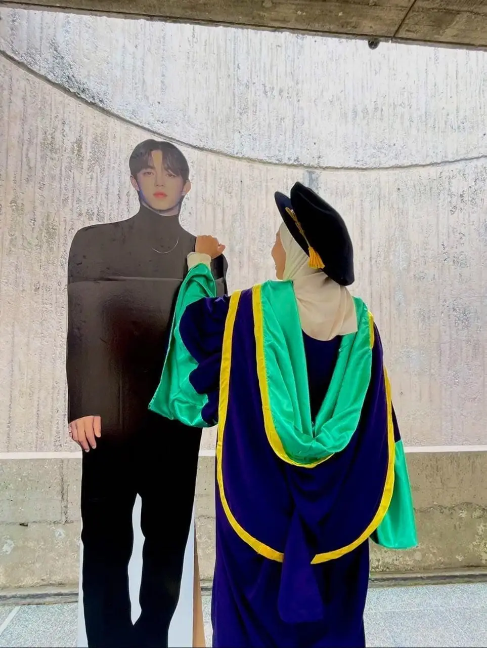 Msian woman takes a professional photo with her scoups bias cutout