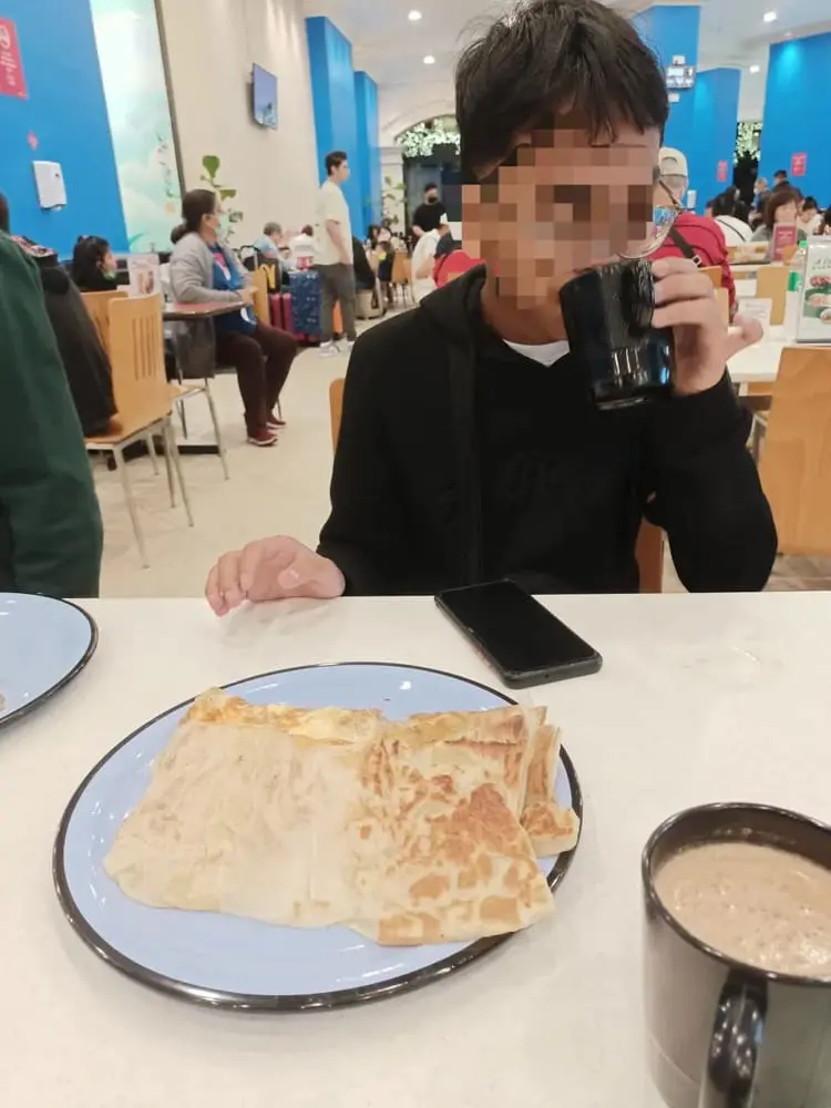 M'sian man having roti canai with a friend