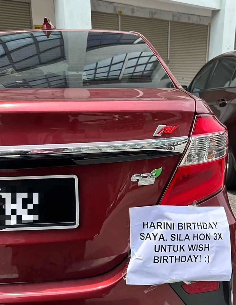 Bezza car with a cute note plastered at it's back where it mentioned honk thrice to wish the driver happy birthday