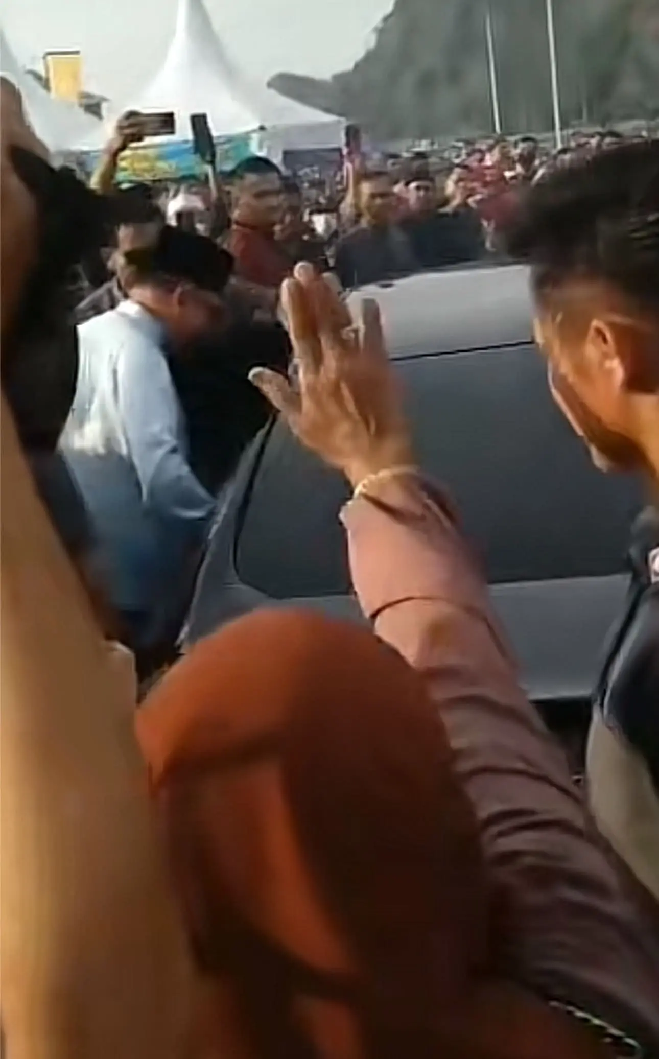 Anwar sitting in the car after the aunty says I love you to him 