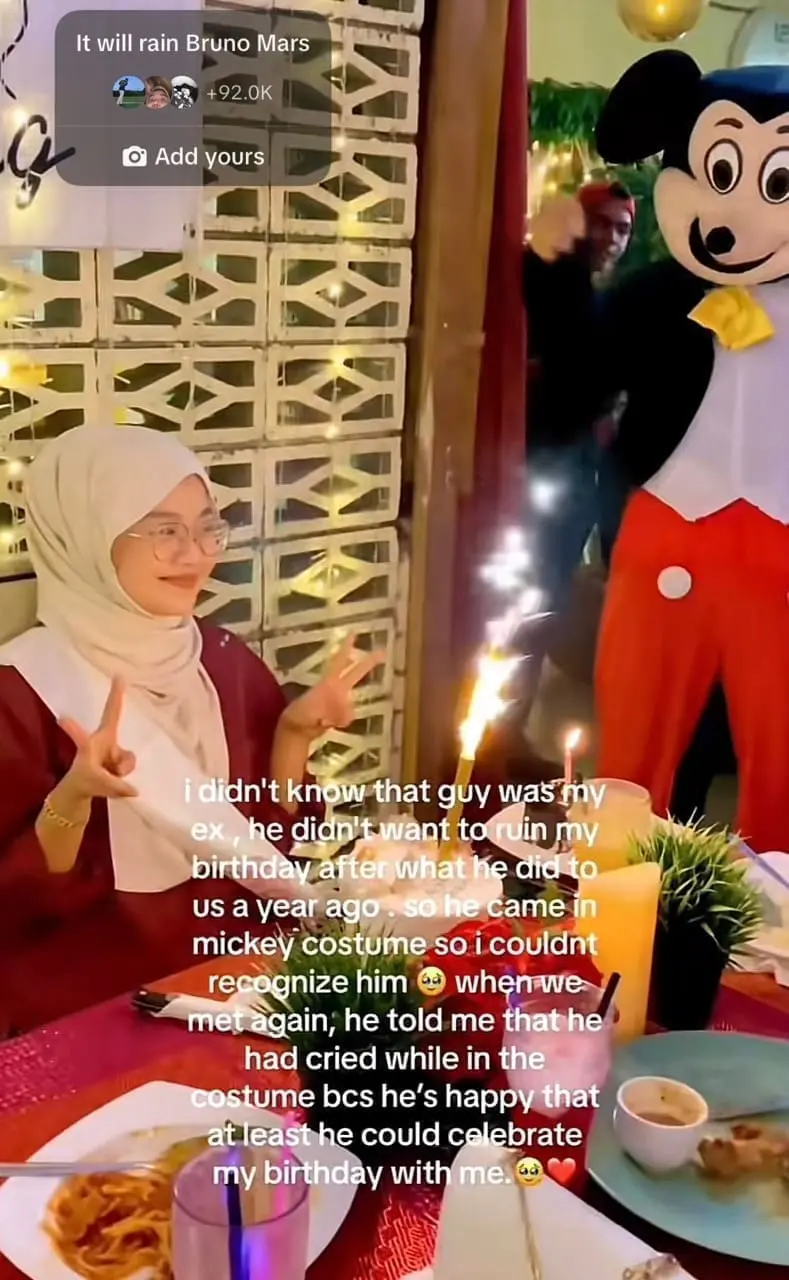 woman poses to camera after her ex disguises himself as mickey mouse