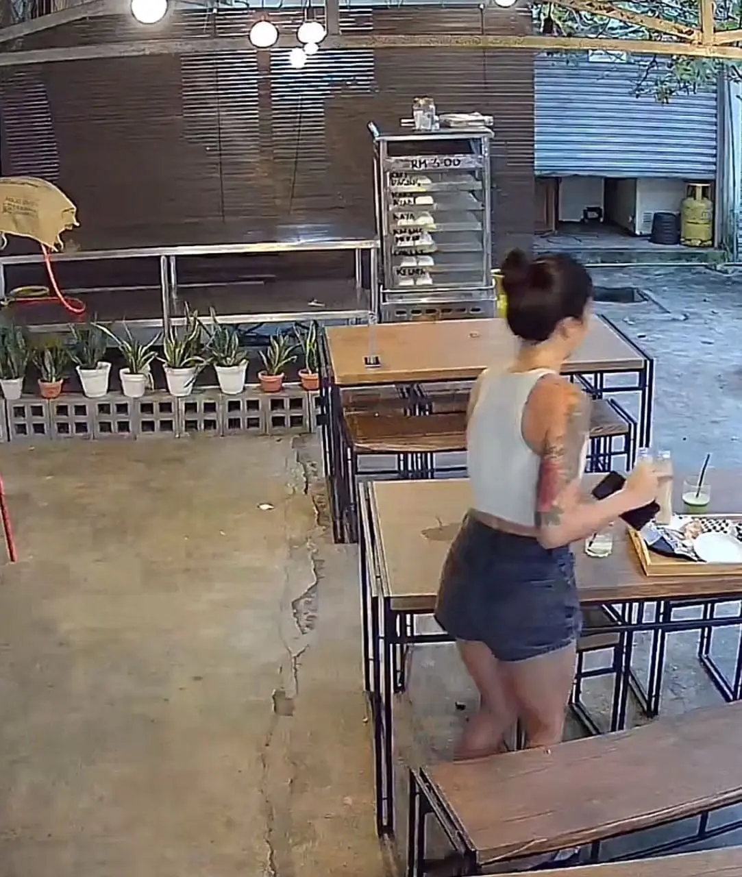 SG woman taking the dish tray filled with dishes from the table