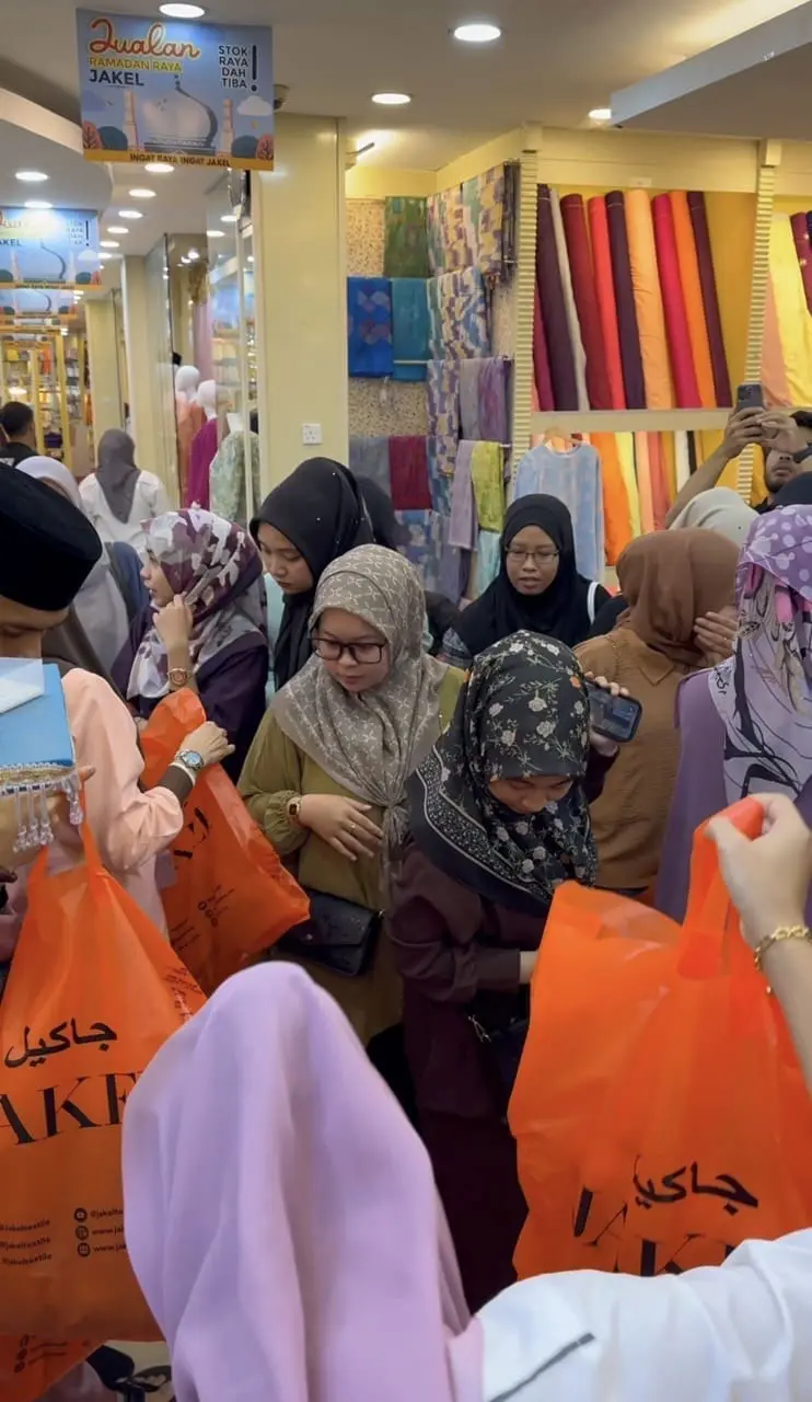 M'sian women shopping Raya clothes at a retail store