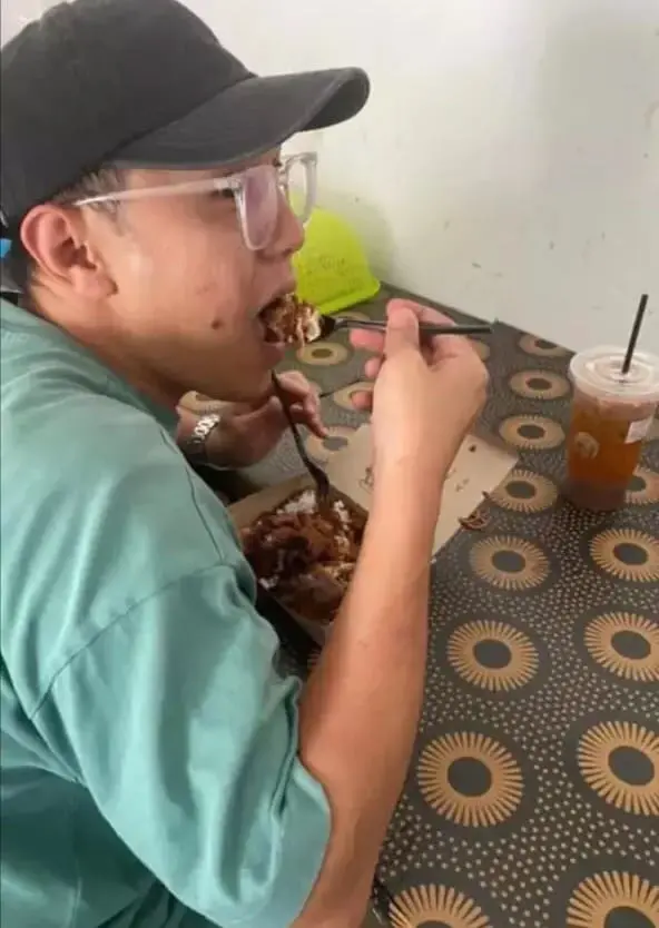 Customer happily eating his nasi lemak with Milo powder