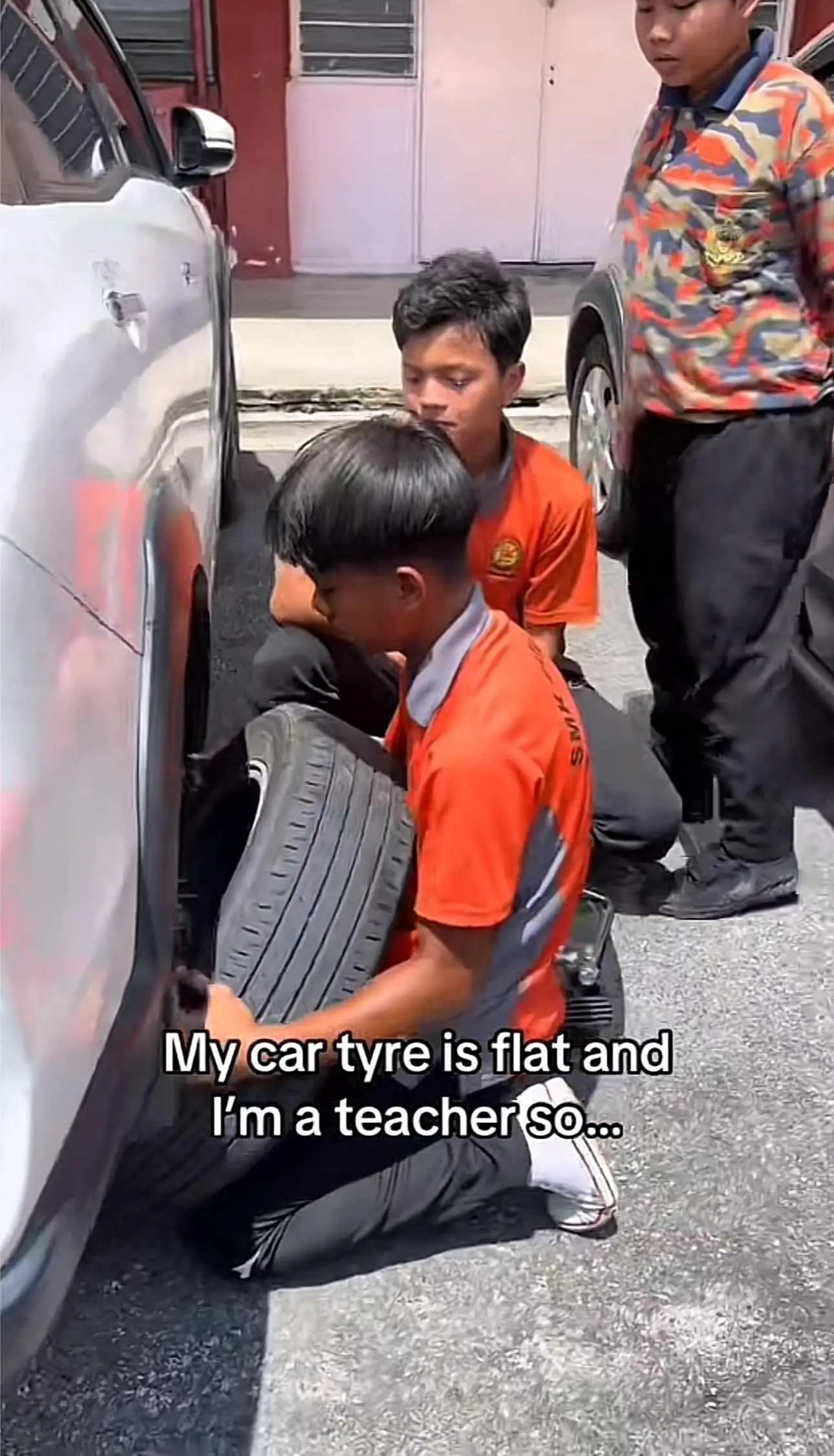 Students helping teacher to fix the tyre