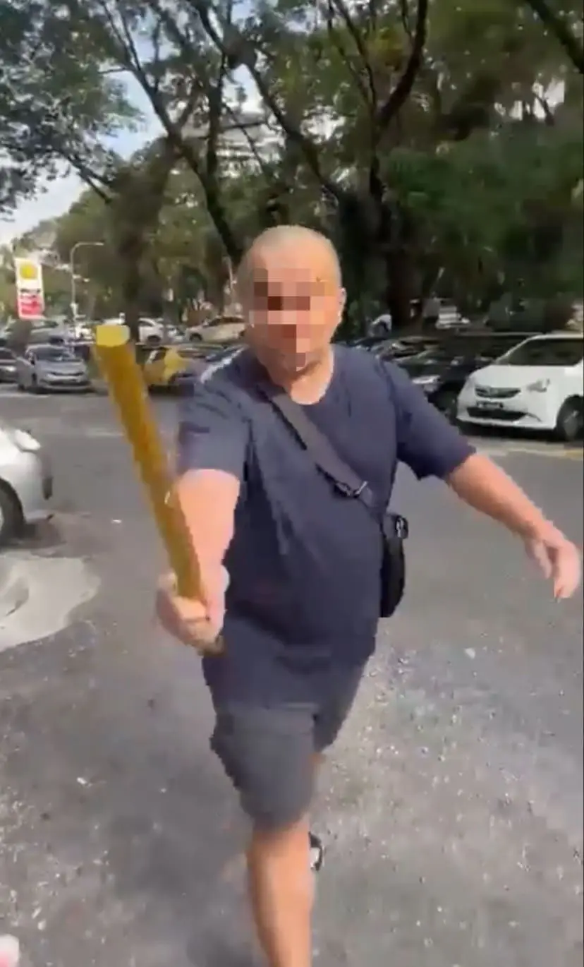 Bald Malaysian man holding a metal rod