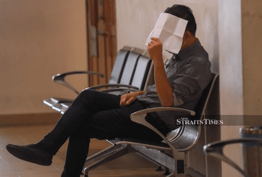 Liau Hai Keong hiding his face