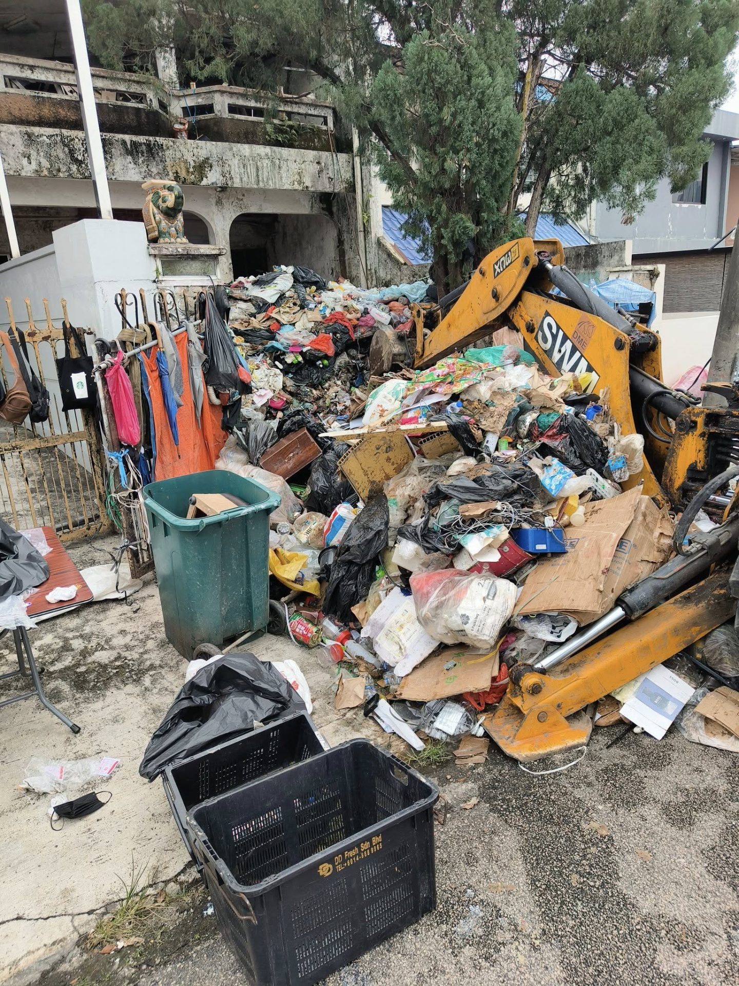 Machine removing trash from man's Johor home