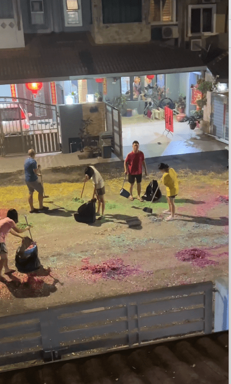 malaysian family cleaning up firecracker debirs after cny celebration