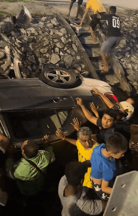 Malaysian rescue overturn car together (3)