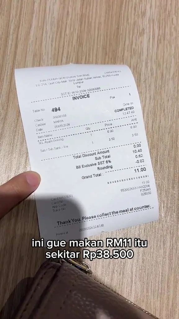 malaysian woman showing a receipt of the meal she purchased